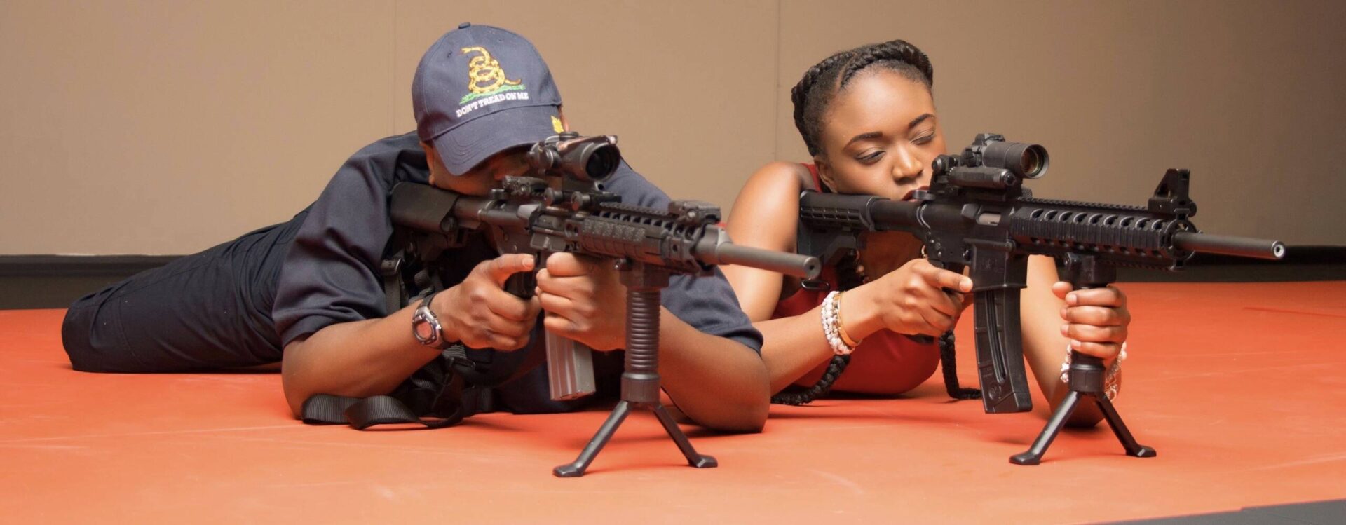 A man and woman are holding guns in their hands.