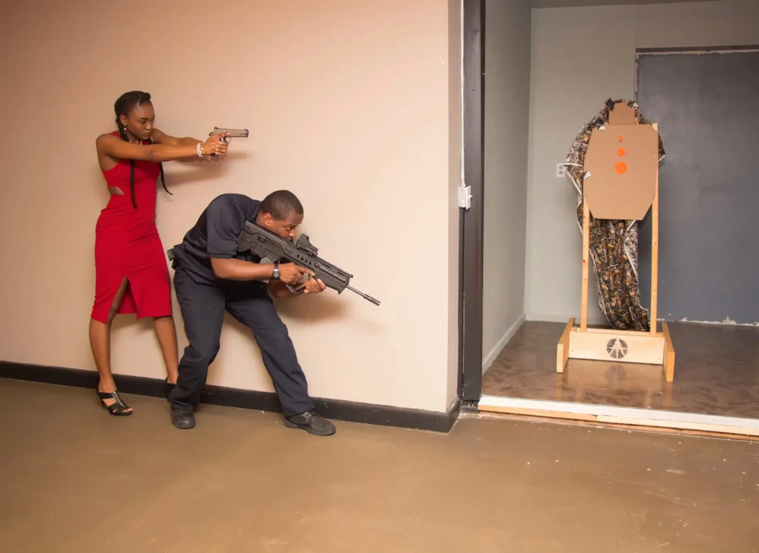 A man and woman in red dress aiming guns