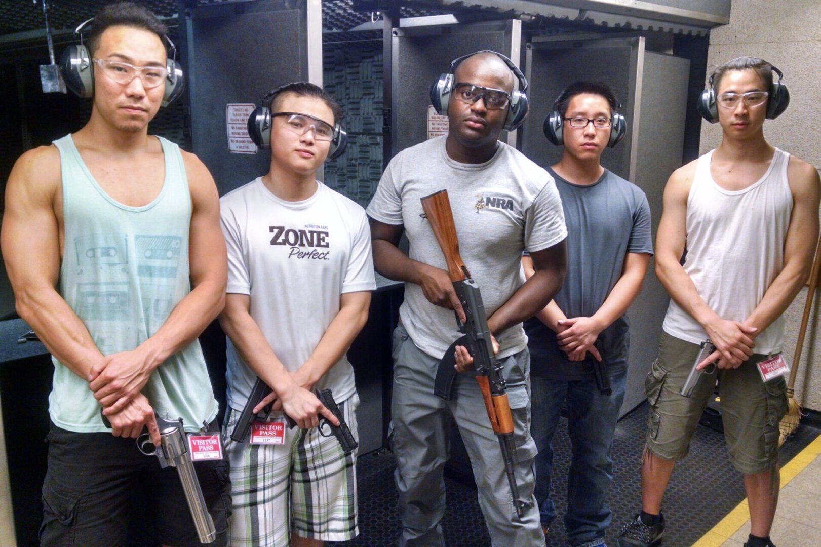 A group of people standing next to each other holding guns.